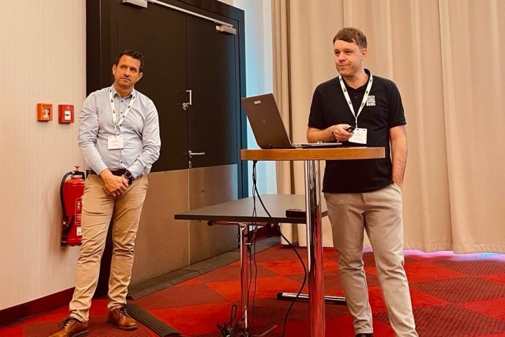 Dominik Welte und Daniel Bayer präsentieren auf der TSN/A Konferenz in Stuttgart 2 Personen an einem Rednerpult