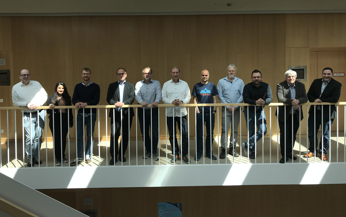 Gruppenbild der Teilnehmer des Projekttreffens: Die 11 Teilnehmer stehen nebeneinander an einem Geländer