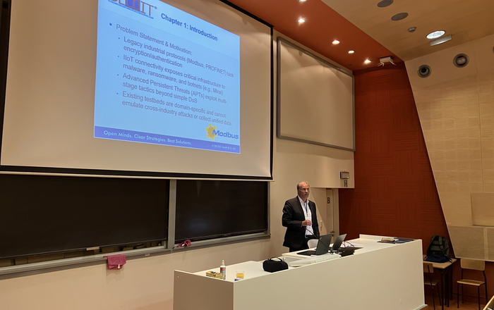 Prof. Dr. Kai-Oliver Detken during his presentation 1 Redner am einem Pult vor einer Leinwandpäsentation