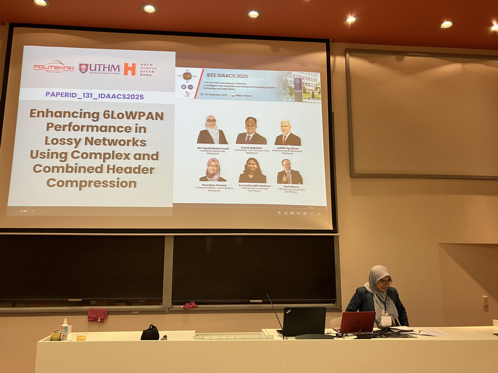 1 Rednerin am einem Pult vor einer Leinwandpäsentation