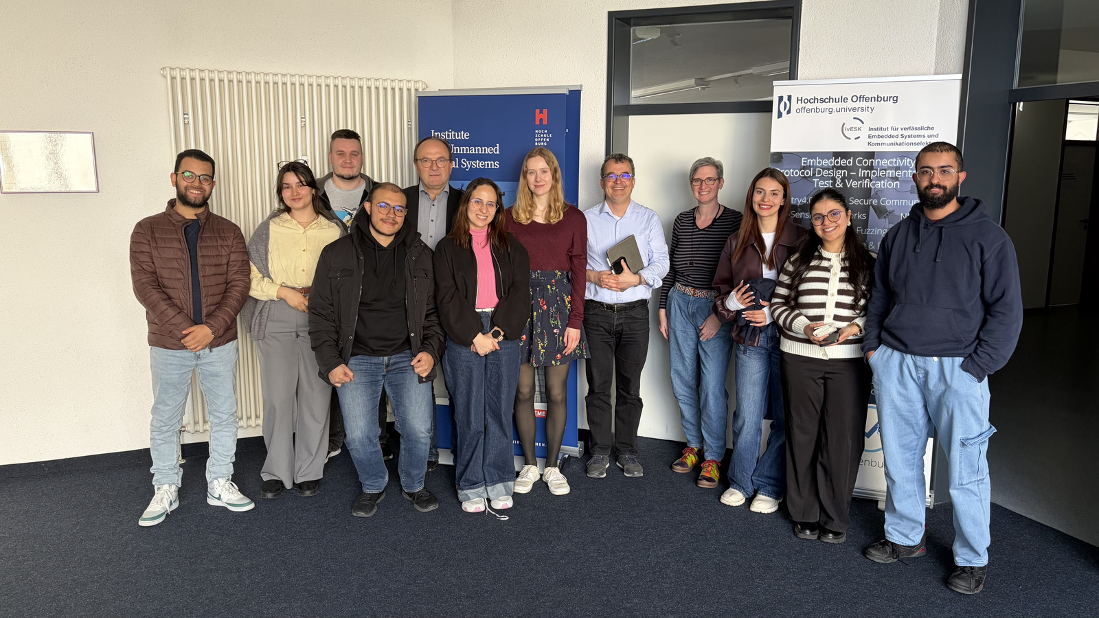 12 Personen n einer Reihe vor 2 RollUps